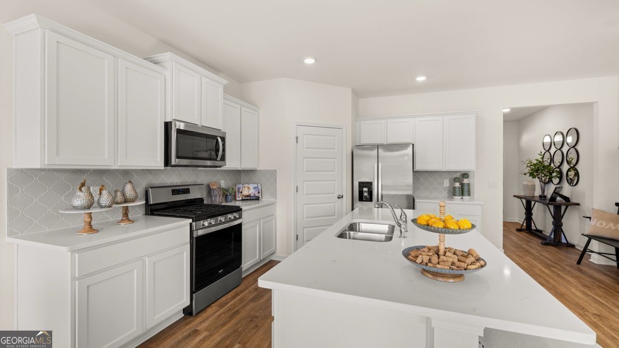 617 Lobelia Way Locust Grove, GA 30248 - Photo 15 of 44 a kitchen with stainless steel appliances granite countertop a sink stove and refrigerator