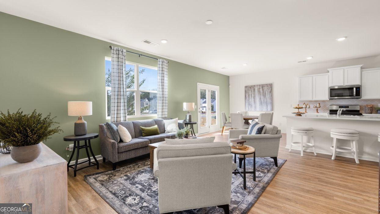617 Lobelia Way Locust Grove, GA 30248 - Photo 20 of 44 a living room with furniture wooden floor and a potted plant