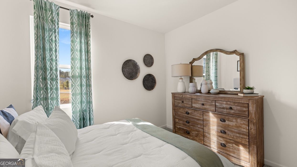 617 Lobelia Way Locust Grove, GA 30248 - Photo 24 of 44 a bedroom with a large bed and a large mirror