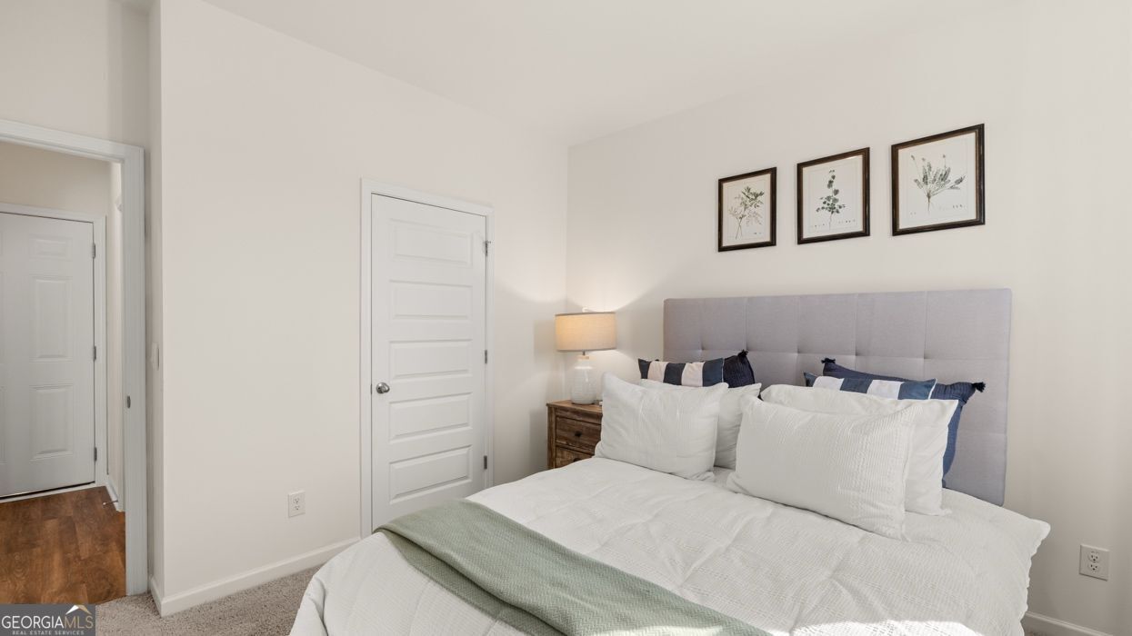 617 Lobelia Way Locust Grove, GA 30248 - Photo 25 of 44 a bedroom with a bed and a painting on the wall