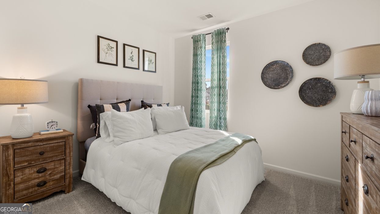 617 Lobelia Way Locust Grove, GA 30248 - Photo 26 of 44 a bedroom with a bed and cabinets