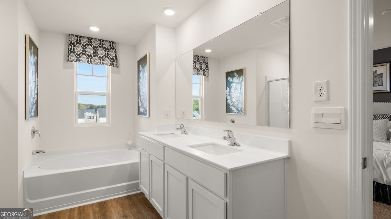 617 Lobelia Way Locust Grove, GA 30248 - Photo 30 of 44 a bathroom with a bathtub a shower a sink and a mirror