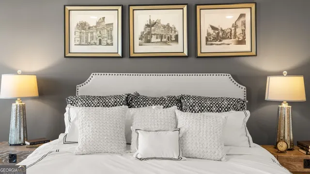 a bedroom with a bed and a lamp on dresser