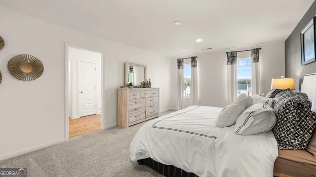 a bedroom with a bed a mirror and lamp