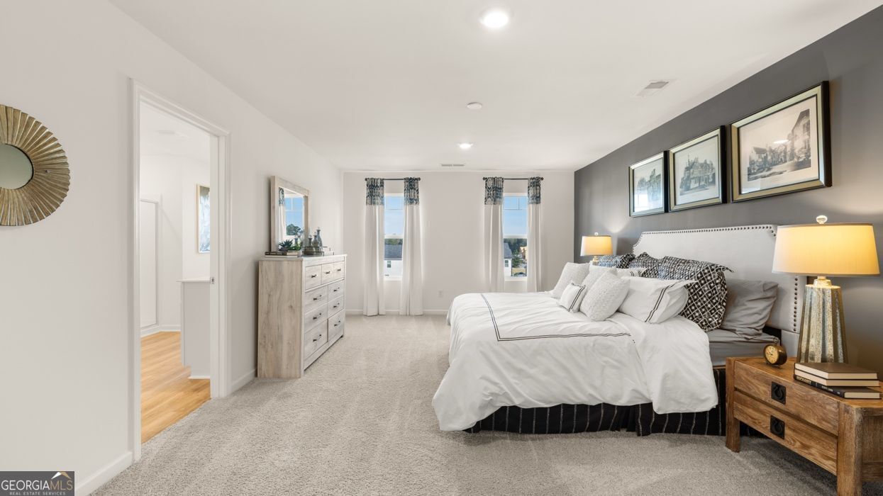 617 Lobelia Way Locust Grove, GA 30248 - Photo 37 of 44 a bedroom with a bed a mirror and lamp