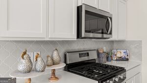 617 Lobelia Way Locust Grove, GA 30248 - Photo 44 of 44 a kitchen with a stove and cabinets