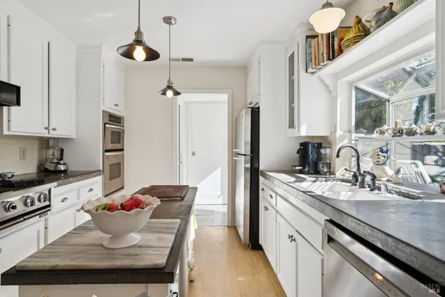 a kitchen with a sink appliances and cabinets