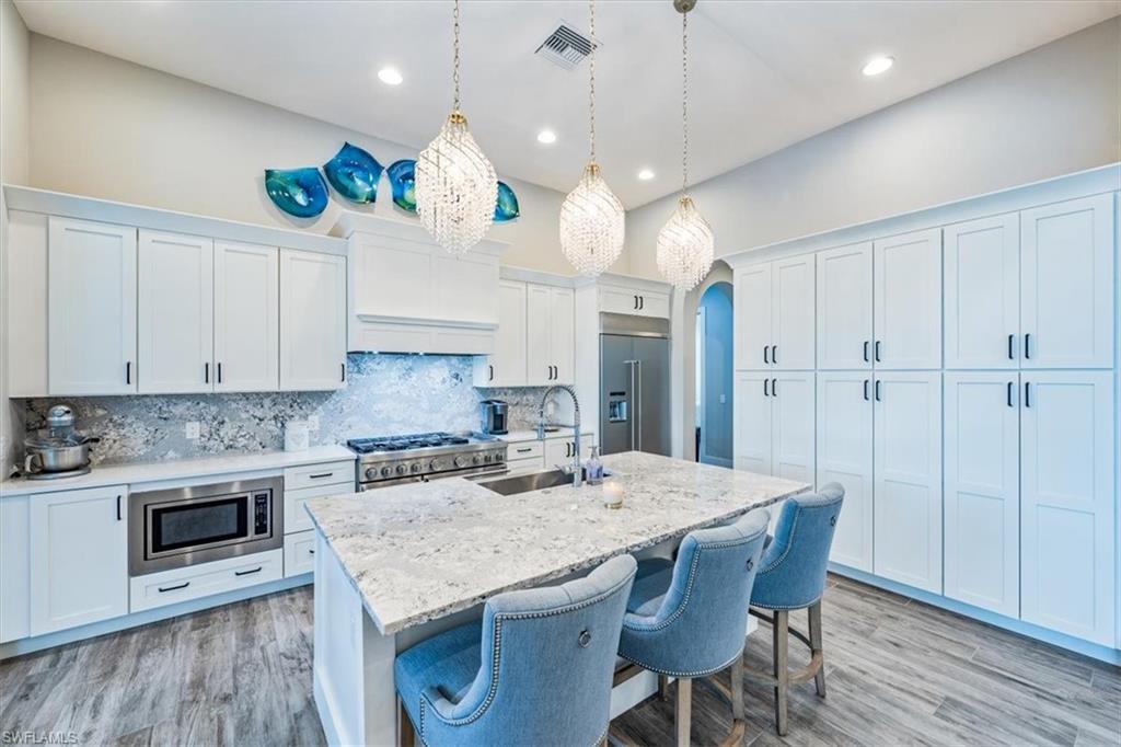 3181 Cullowee Lane Naples, FL 34114 - Photo 11 of 43 an open kitchen with a table and chairs in it