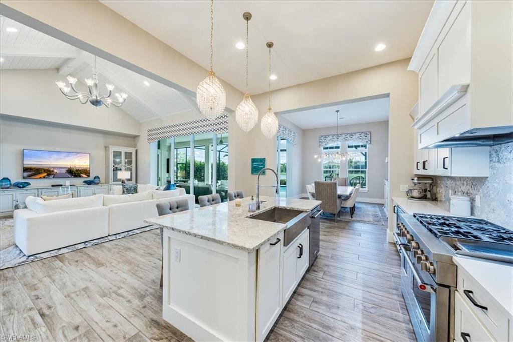 3181 Cullowee Lane Naples, FL 34114 - Photo 14 of 43 a large white kitchen with lots of counter space a sink appliances and a large window