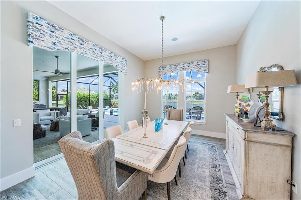 3181 Cullowee Lane Naples, FL 34114 - Photo 15 of 43 a dining room with furniture a chandelier and wooden floor