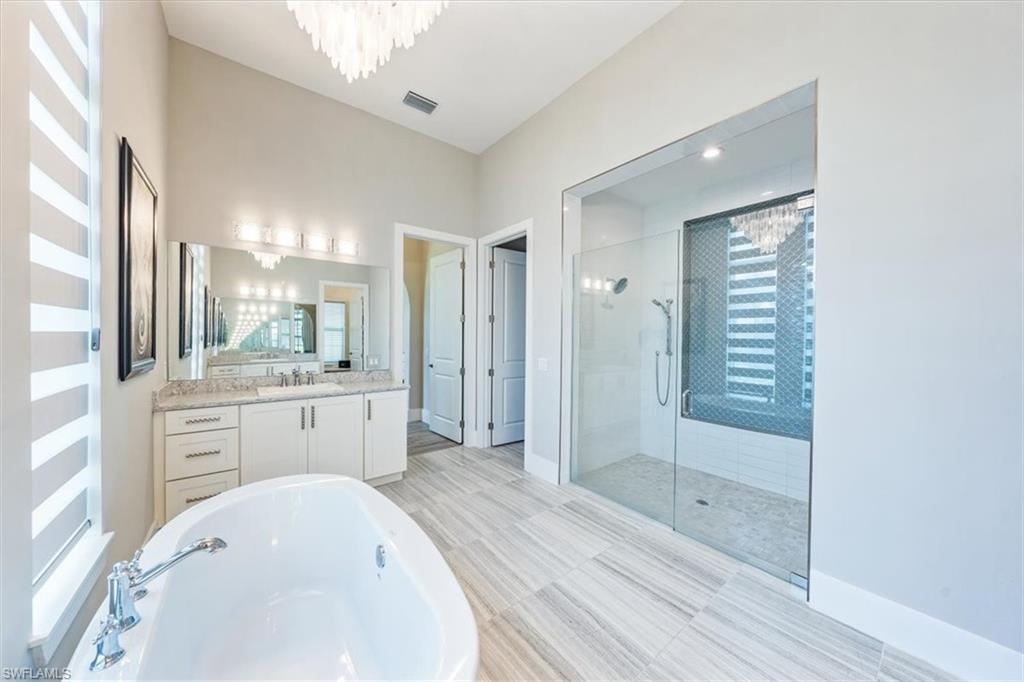 3181 Cullowee Lane Naples, FL 34114 - Photo 21 of 43 a bathroom with a bathtub shower sink and mirror