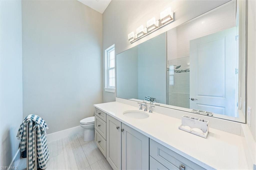 3181 Cullowee Lane Naples, FL 34114 - Photo 24 of 43 a bathroom with a double vanity sink mirror and toilet