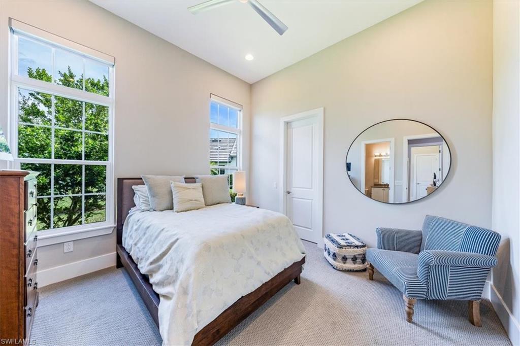 3181 Cullowee Lane Naples, FL 34114 - Photo 25 of 43 a bedroom with a bed a couch and a large window