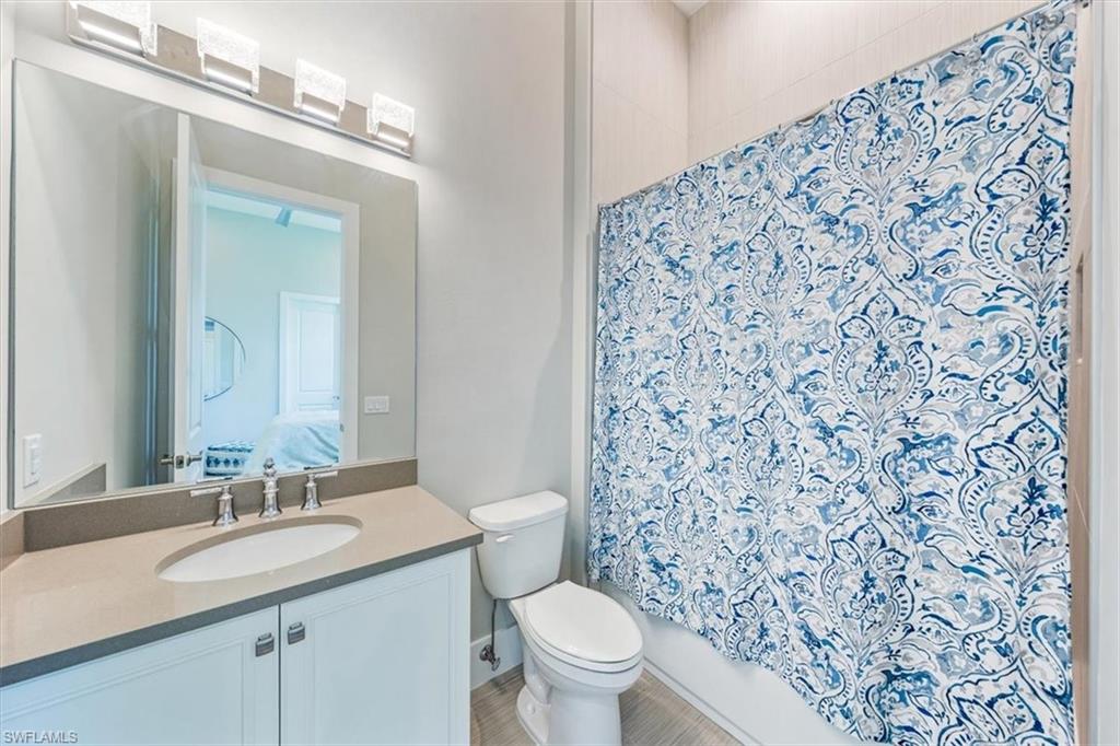 3181 Cullowee Lane Naples, FL 34114 - Photo 26 of 43 a bathroom with a granite countertop sink a toilet and a mirror