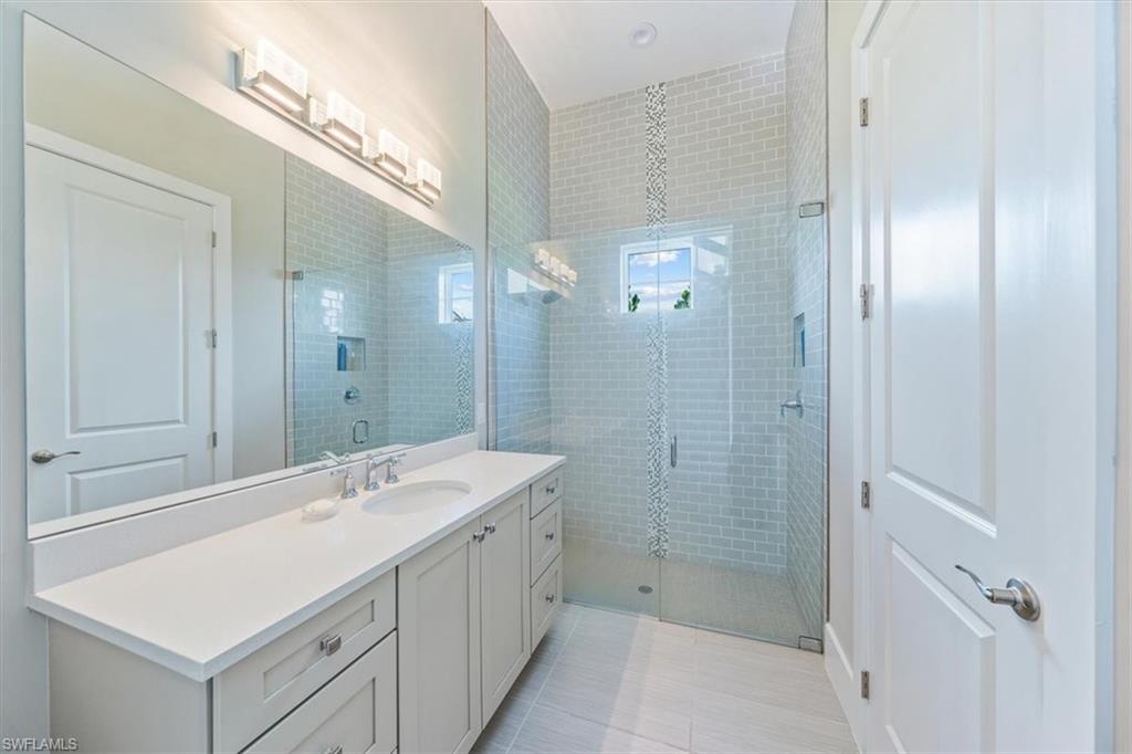 3181 Cullowee Lane Naples, FL 34114 - Photo 28 of 43 a bathroom with a sink a shower and a mirror