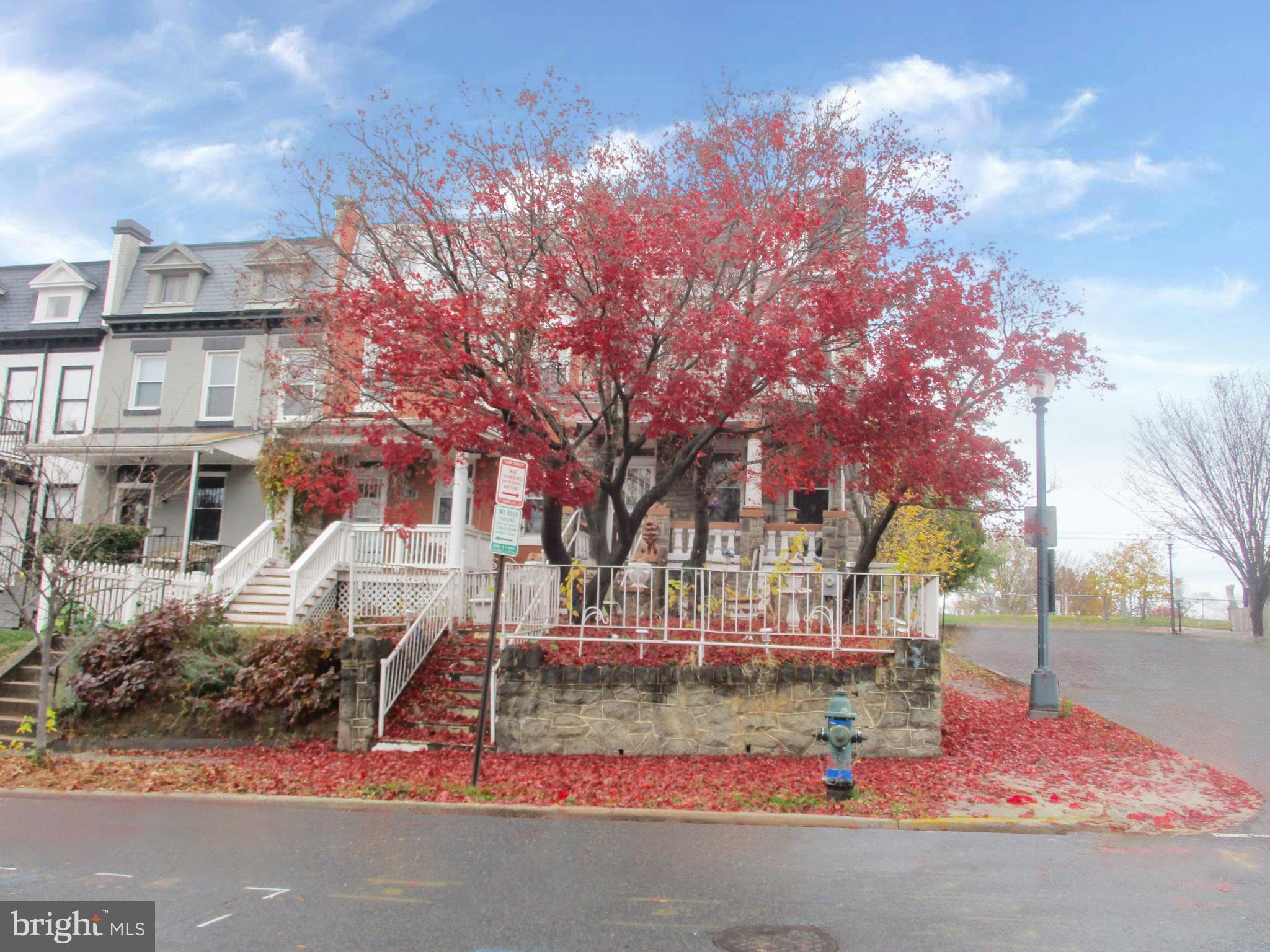 a front view of a building with large trees