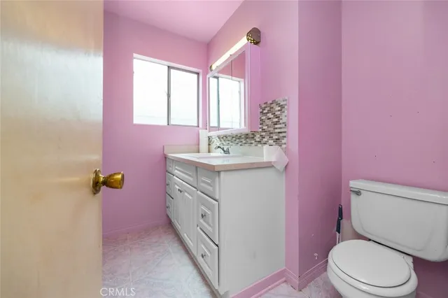 a bathroom with a sink toilet vanity and window