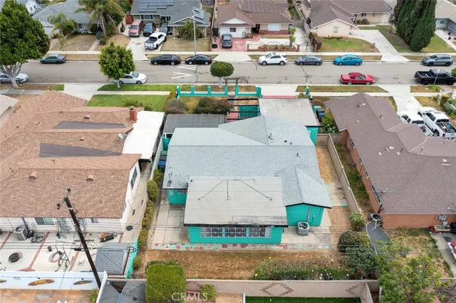 an aerial view of residential houses with outdoor space and parking