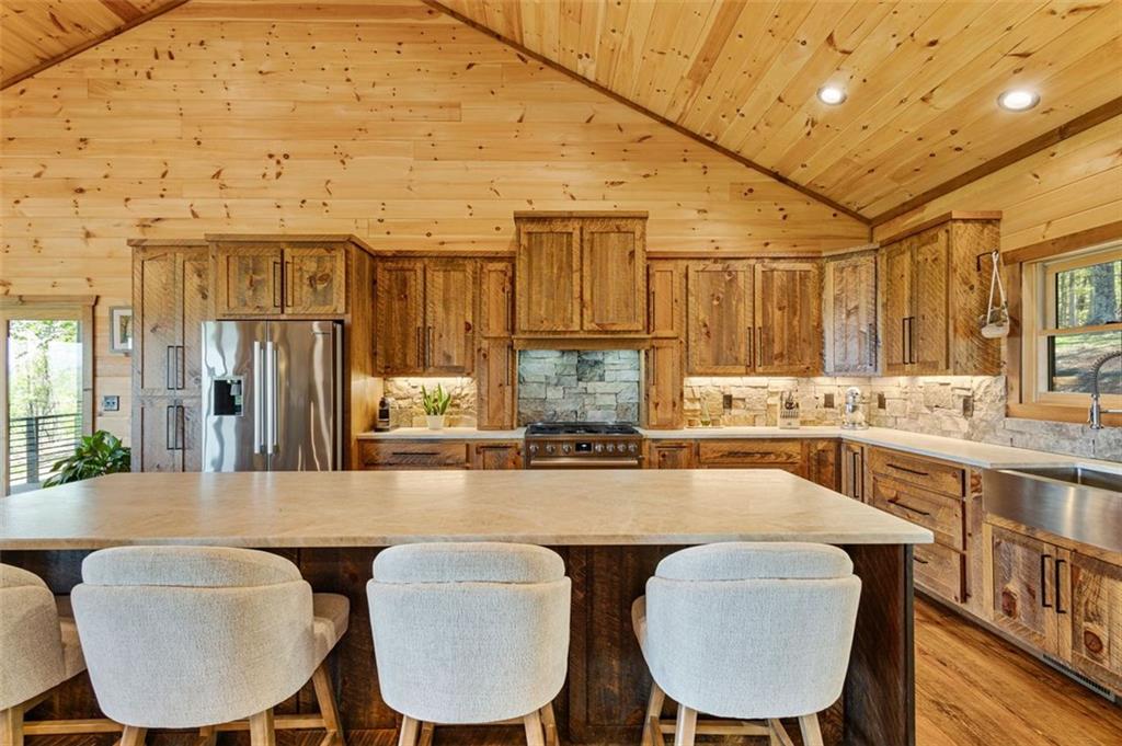 95 Upper Ridge Trail Blairsville, GA 30512 - Photo 24 of 71 a kitchen with stainless steel appliances granite countertop a table chairs and a refrigerator
