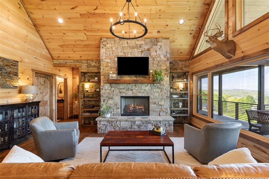 95 Upper Ridge Trail Blairsville, GA 30512 - Photo 32 of 71 a living room with furniture a fireplace and a floor to ceiling window