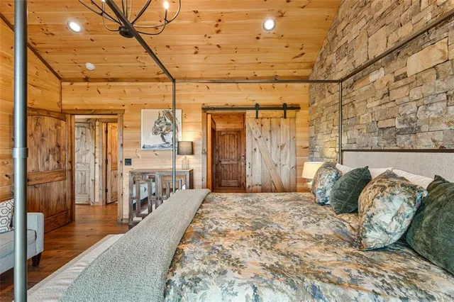a room with stainless steel appliances kitchen island granite countertop furniture and a wooden floor