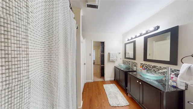 a bathroom with a granite countertop double vanity sink and mirror