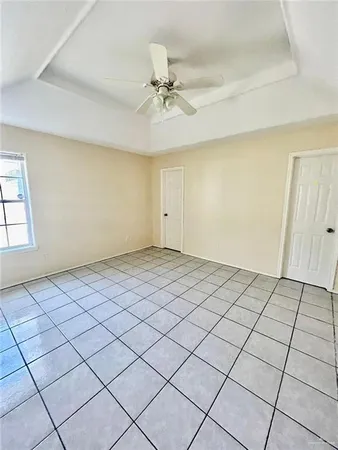 a view of a room with a ceiling fan and window