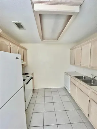 a kitchen with a sink a stove and white cabinets