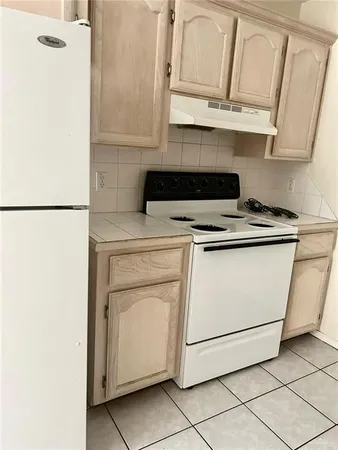 a kitchen with granite countertop white cabinets and white appliances