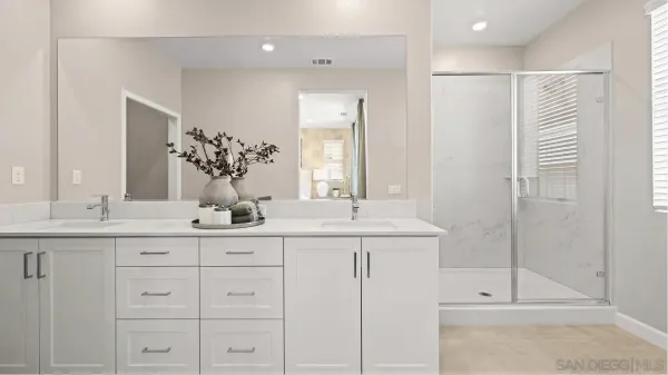 a bathroom with double sink and a mirror