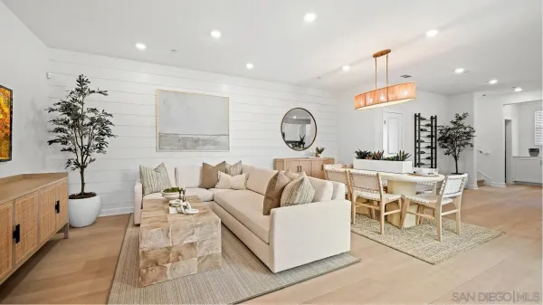 a living room with furniture a clock and a potted plant