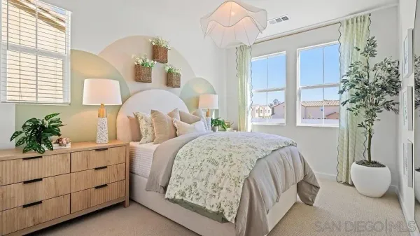 a bedroom with a bed and a potted plant