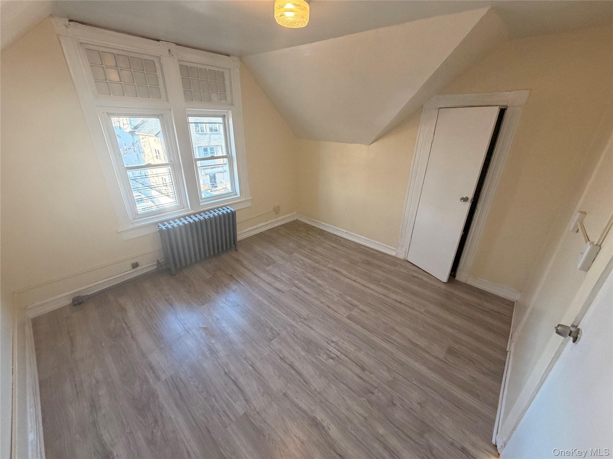 315 South 4th Avenue, Unit 3 Mount Vernon, NY 10550 - Photo 6 of 10 an empty room with wooden floor and windows