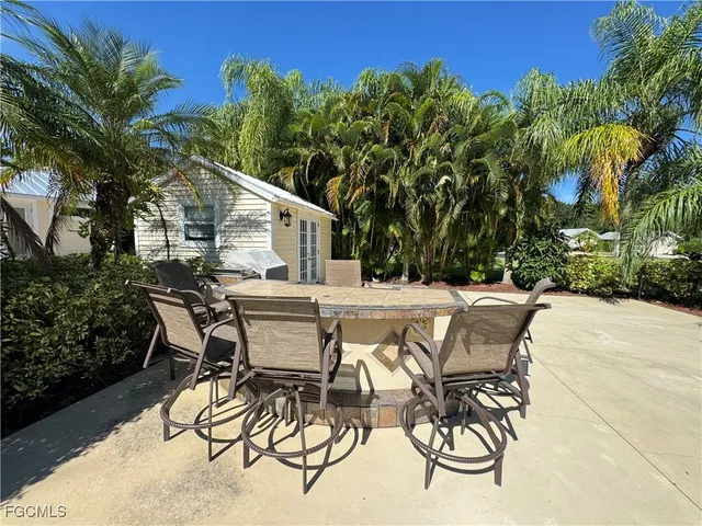 a view of a patio with table and chairs and potted plants with wooden fence