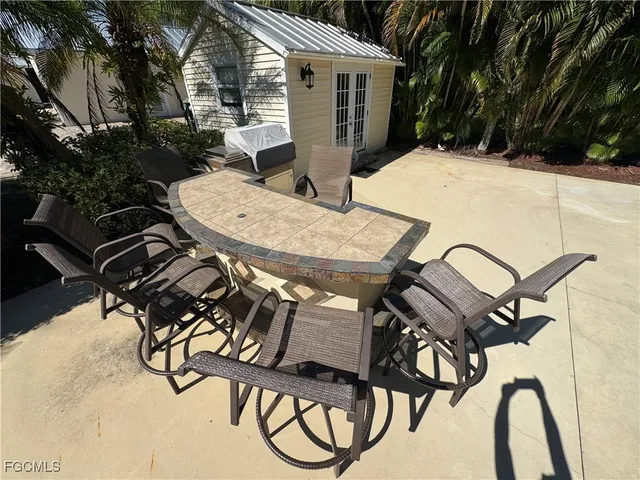a view of a patio with table and chairs with wooden floor and fence