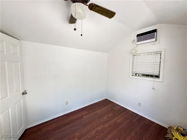 an empty room with a window and wooden floor