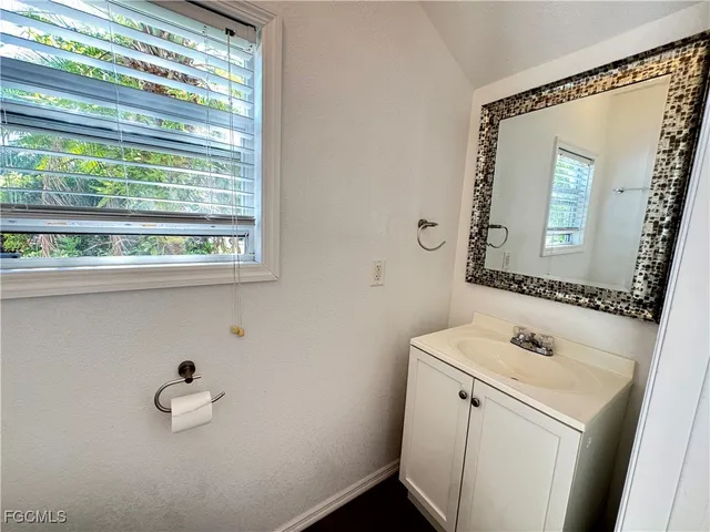 a bathroom with a granite countertop sink and a mirror