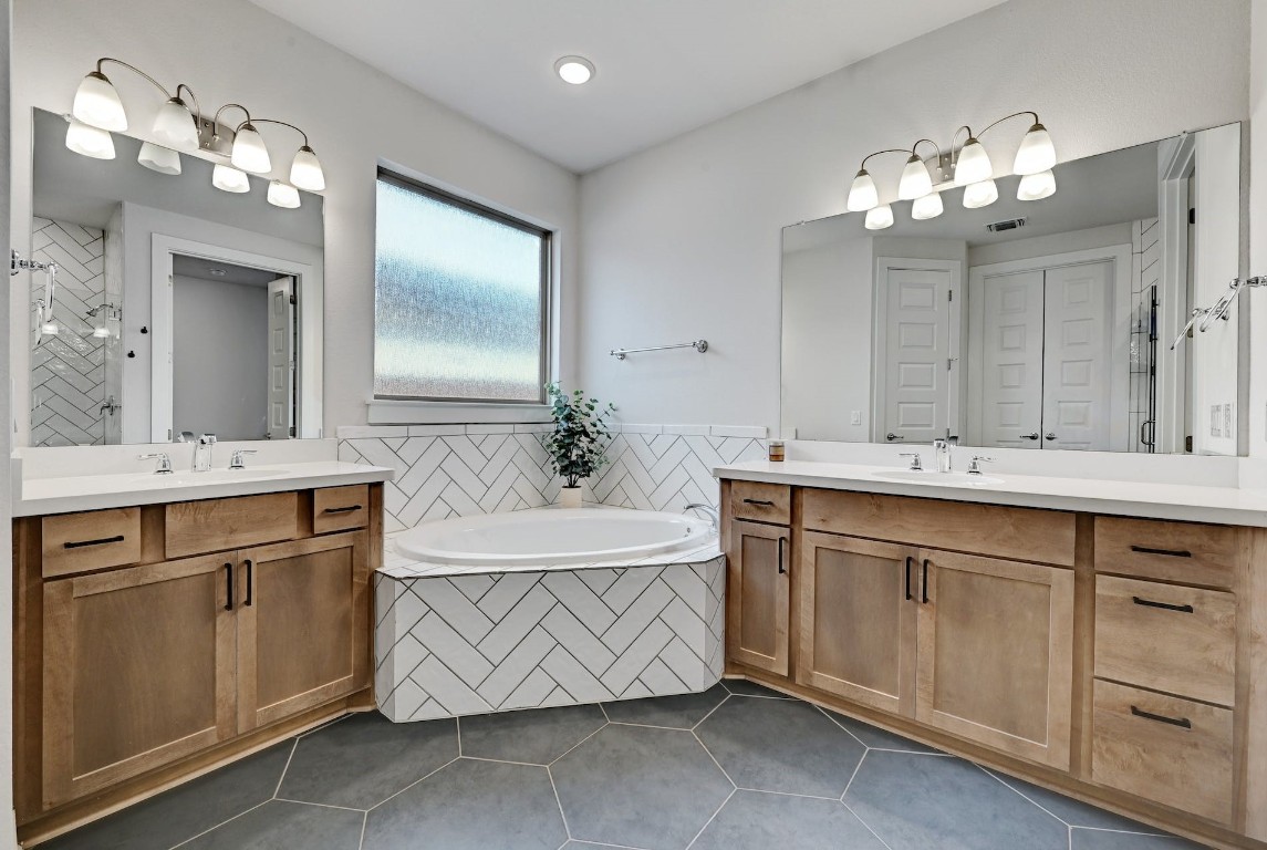 8509 Silverthorne Street Austin, TX 78744 - Photo 17 of 39 a bathroom with a sink double vanity and a mirror