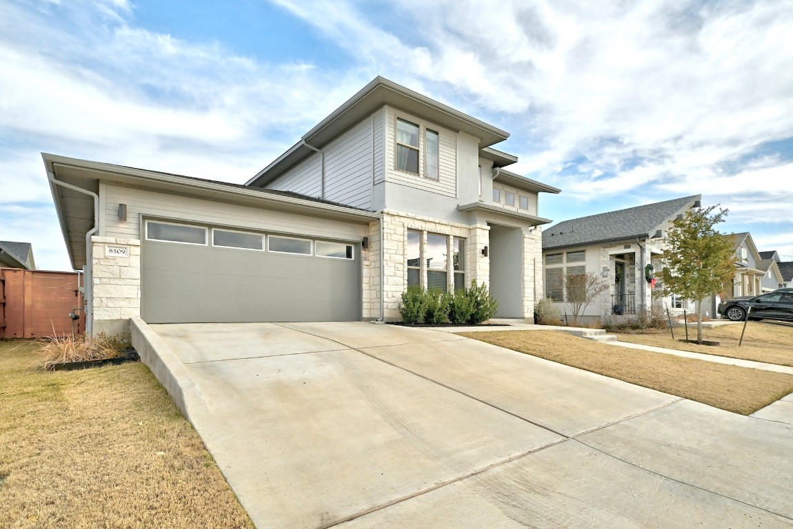 8509 Silverthorne Street Austin, TX 78744 - Photo 2 of 39 a front view of a house with a yard and garage