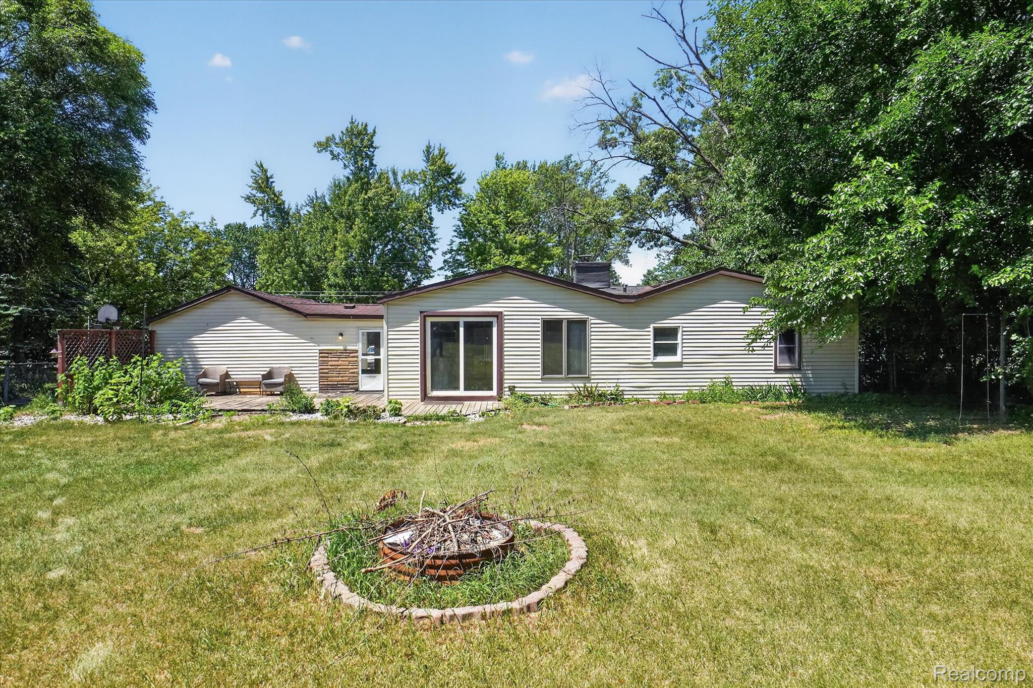 508 Deland Road Flushing, MI 48433 - Photo 30 of 38 Expansive green space featuring a fire pit with stone surround