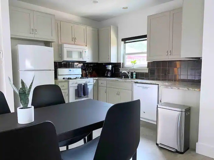 2012 Willow Street, Unit B Austin, TX 78702 - Photo 7 of 15 a kitchen with a table chairs a refrigerator a stove a microwave and cabinets