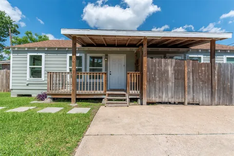 a view of a house with a yard and wooden fence