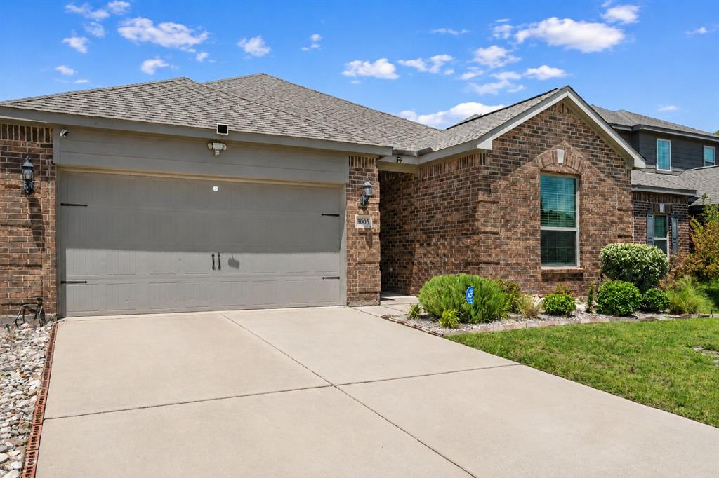 Brick exterior with a gabled roof and an attached garage