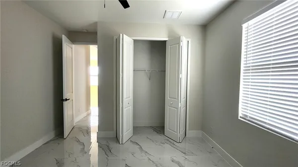 an empty room with windows and closet