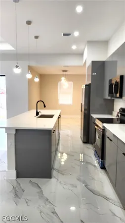 a kitchen with kitchen island a sink stainless steel appliances and cabinets