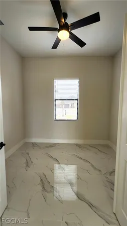 en empty room with windows and fan