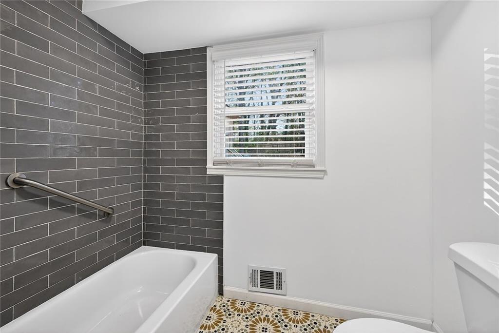 1200 Silver Hill Road Stone Mountain, GA 30087 - Photo 14 of 26 a bathroom with a bathtub and a toilet