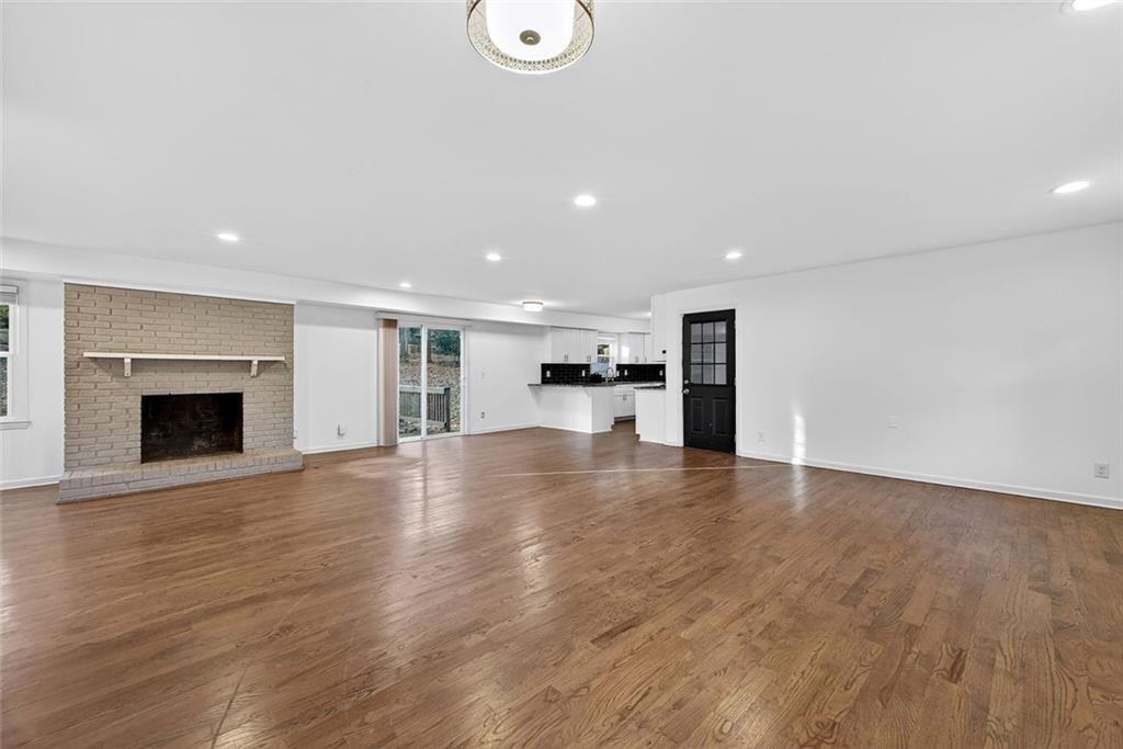1200 Silver Hill Road Stone Mountain, GA 30087 - Photo 4 of 26 a view of empty room with wooden floor and fireplace