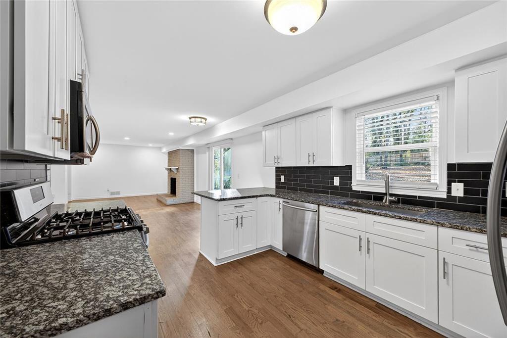 1200 Silver Hill Road Stone Mountain, GA 30087 - Photo 7 of 26 a kitchen with stainless steel appliances granite countertop a sink stove and cabinets