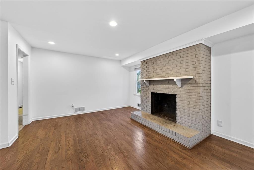 1200 Silver Hill Road Stone Mountain, GA 30087 - Photo 10 of 26 a view of an empty room with wooden floor fireplace and a window